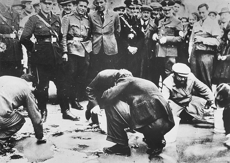 Soldados nazis y residentes de Viena, Austria, observan cómo los judíos se ven obligados a ponerse de rodillas y fregar el pavimento luego de la anexión austríaca a Alemania. Foto: Museo Conmemorativo del Holocausto de los Estados Unidos/Dominio público, vía Wikimedia Commons.