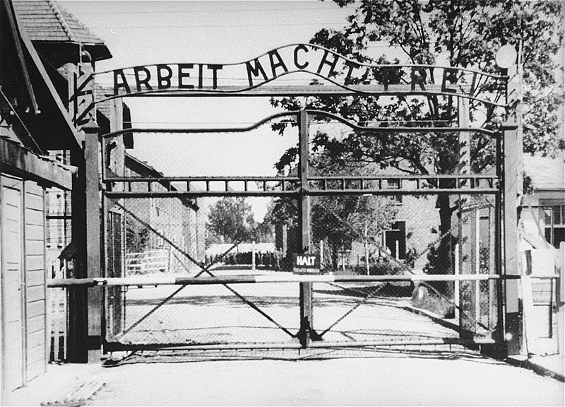 Entrada al campo principal de Auschwitz (Auschwitz I). La puerta lleva el lema "Arbeit Macht Frei", el trabajo te hace libre. La fotografía fue tomada el 15 de mayo de 1945. Foto: Public domain/via Wikimedia Commons.