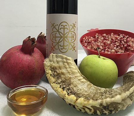 Un shofar, granadas, vino, manzanas y miel, algunos de los elementos más tradicionales de la tradición de Rosh Hashaná. Foto: N100a at Hebrew Wikipedia., Attribution, via Wikimedia Commons.